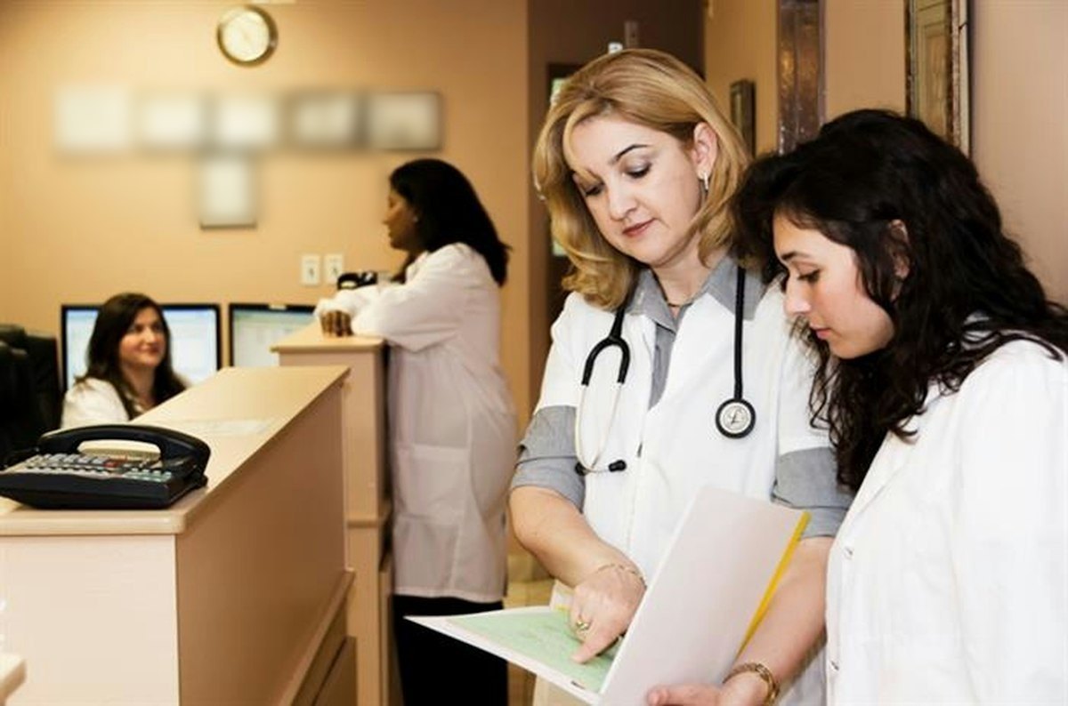 Clinicians reviewing a patient chart at a clinic reception